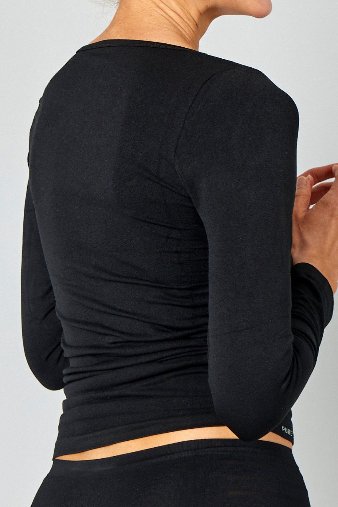 Seamless træningstrøje i sort, lavet af blødt og åndbart stof. Giver et feminint og tidløst look.